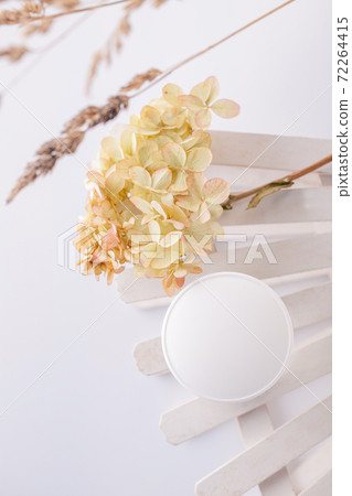 white cosmetics container and hydrangea inflorescence on a white background. Health, body care 72264415