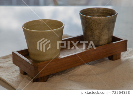 Two ceramics mugs handmade on marble table of living room. Two ceramics mugs handmade on marble table of living room. 72264528