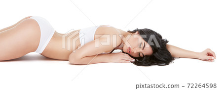 Fitness young woman with a beautiful body laying on white background Fitness young woman with a beautiful body laying on white background 72264598