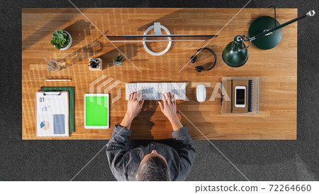 Top view of businessman working on computer at desk with keyable screen in home office. 72264660