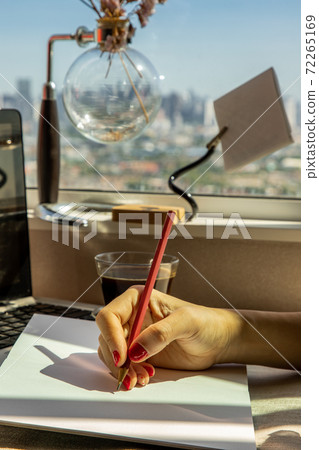 Hand of business woman writing on paper at her workstation. 72265169