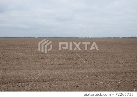 Beautiful sky over a plowed agricultural field. Agro-industrial landscape. A plowed farm field. Cultivated soil during the day. Beautiful sky over a plowed agricultural field. Agro-industrial landscape. A plowed farm field. Cultivated soil during the day. 72265735