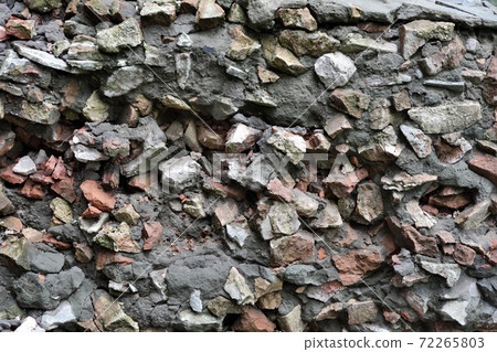 Cement mix with fragments of broken brick and stones as a background. Cement mix with fragments of broken brick and stones as a background. 72265803