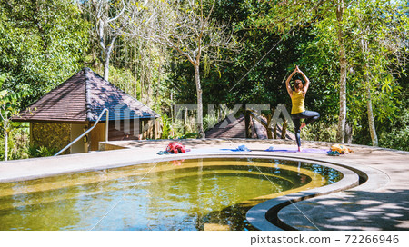 Asian women relax in the holiday. Play if yoga in the Pool Hot Spring, Relaxing in a natural hot springs.Yoga posture exercise. 72266946