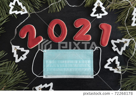 Garland, inscription 2021 and surgical mask. Coronavirus quarantine in 2021. Garland, inscription 2021 and surgical mask. Coronavirus quarantine in 2021. 72268178