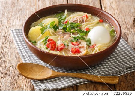 Homemade chicken soup with noodles, potatoes, boiled egg and herbs close-up in a plate. horizontal 72269839