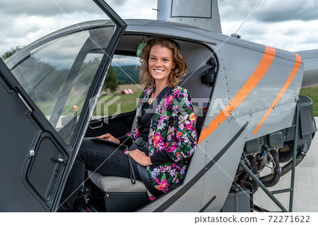 transport by helicopter. A young woman in a helicopter travels to a buseness meeting 72271622