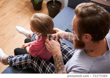 Daddy combing his little daughter's hair Daddy combing his little daughter's hair 72273369