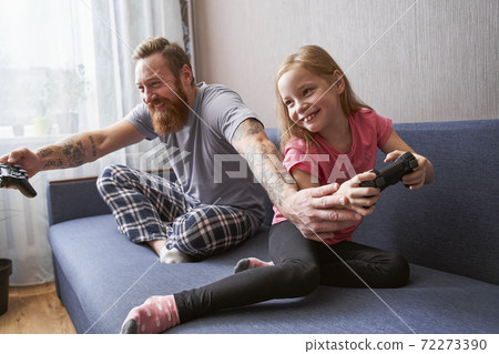 Dad and cute little daughter sitting on couch Dad and cute little daughter sitting on couch 72273390