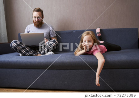 Girl laying at the sofa near her handsome bearded father 72273399