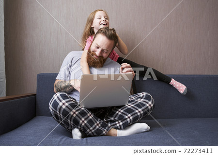 Father holding laptop on his lap sitting at lotus pose 72273411