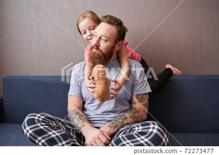 Daughter hugging her bearded father 72273477