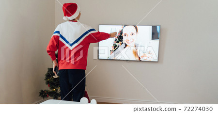 Millennial young woman using phone at home in Christmas Eve. Online holiday shopping, quarantine 72274030