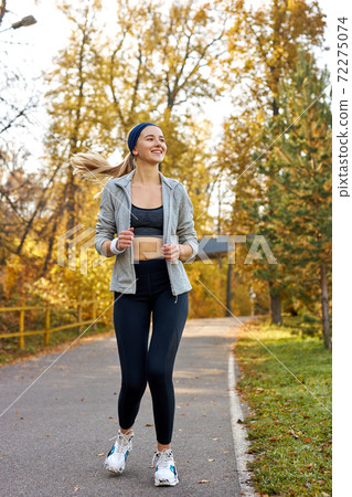 pretty athletic female running at sunny autumn day 72275074