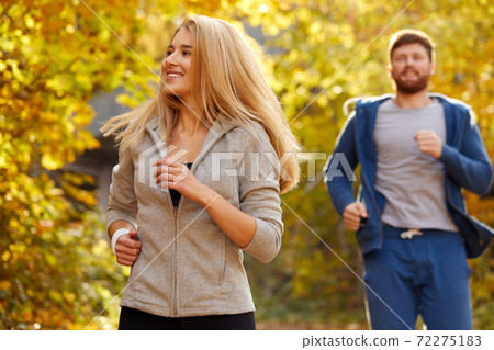 young couple running at autumn forest trail young couple running at autumn forest trail 72275183
