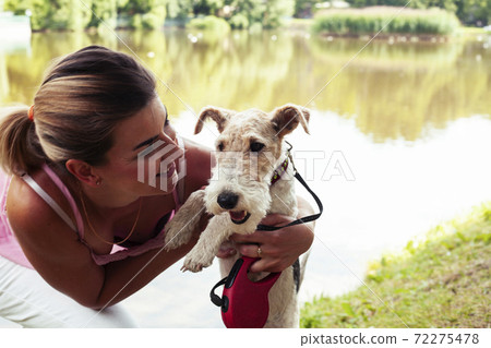 pretty woman with cute dog fox terrier playing in green sunny park, lifestyle people concept 72275478