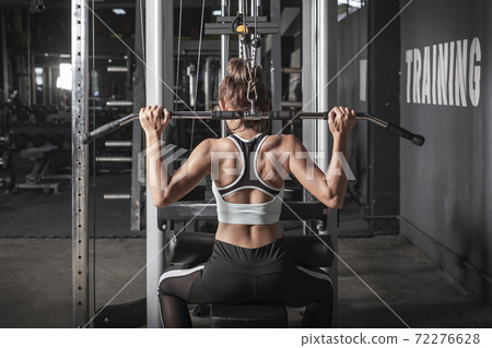 young fitness woman workout with exercise-machine in gym young fitness woman workout with exercise-machine in gym 72276628