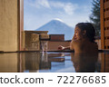 Beautiful woman enjoy onsen (mineral hot bath) in morning and seeing view of Fuji mountain in japan 72276685