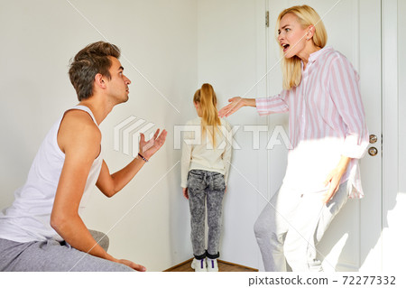 daughter is in the corner of the room while parents arguing daughter is in the corner of the room while parents arguing 72277332