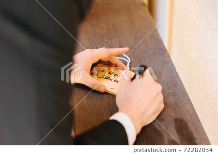 Writing a wish on a votive tablet 72282034