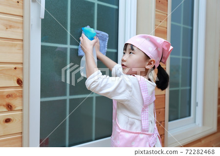 A 5-year-old girl helping to clean the windows A 5-year-old girl helping to clean the windows 72282468