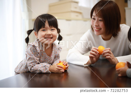 Parent and child with oranges 72282753