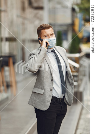 Businessman in a mask use the phone Businessman in a mask use the phone 72282913