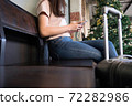 Woman with travel trolley luggage in hotel lobby.Travel concept. 72282986