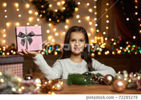 little child girl holding Christmas gift box little child girl holding Christmas gift box 72285278