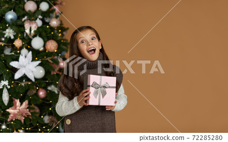 cute joyful little child girl holding Christmas gift box cute joyful little child girl holding Christmas gift box 72285280