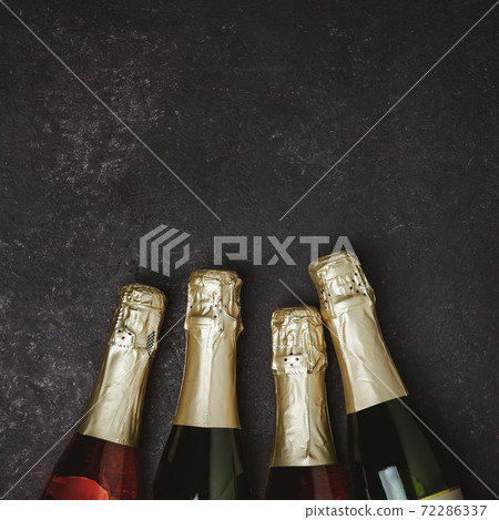 Four champagne bottles on dark background, flat lay Four champagne bottles on dark background, flat lay 72286337