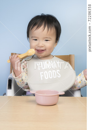 Baby eating baby food 72286358