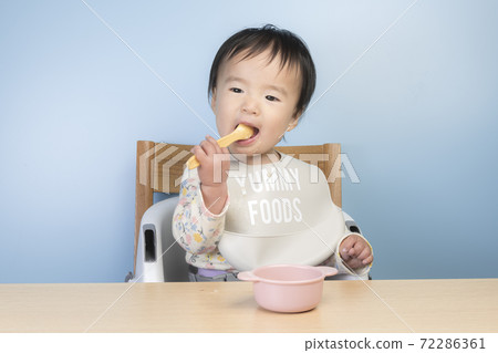 Baby eating baby food Baby eating baby food 72286361