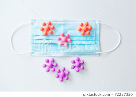 development of the game in the period of the pandemic. Health and recreation concept of family safety in the context of the covid-19 coronavirus pandemic. the medical mask on the multi-colored toys 72287320