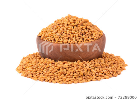 Fenugreek seeds in wooden bowl, isolated on white background. Shambala, helba seeds. 72289000