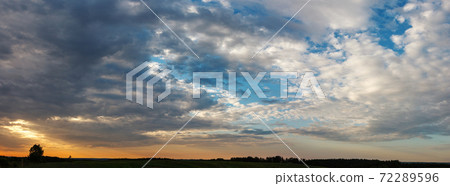 cloudy sunset over green meadow, landscape 72289596