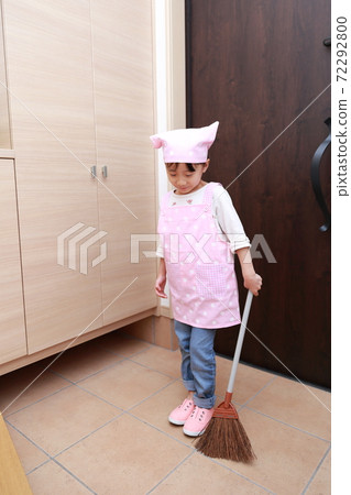 A 5-year-old girl helping to clean the front door A 5-year-old girl helping to clean the front door 72292800