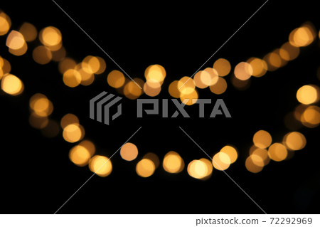 Blurred golden festive lights. Blurred garland backdrop for holidays and parties. Christmas Party concept 72292969