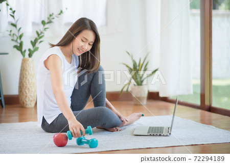 Beautiful asian woman staying fit by exercising at home for healthy trend lifestyle 72294189
