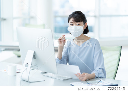 Woman wearing a mask in the office Woman wearing a mask in the office 72294245