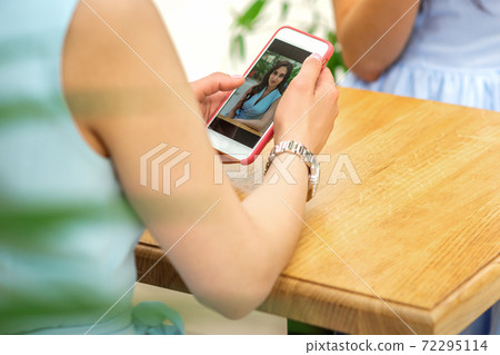 Woman looking at photos on phone 72295114