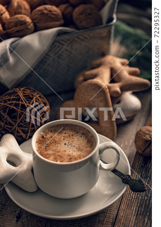 Hot flavored nutty cappuccino with caramel and gingerbread Christmas cookies on a rustic table. Vertical shot. Soft focus Hot flavored nutty cappuccino with caramel and gingerbread Christmas cookies on a rustic table. Vertical shot. Soft focus 72295327