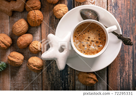 Hot nutty cappuccino with caramel and gingerbread Christmas cookies on a rustic table. Homemade sweet pastries. Top view Hot nutty cappuccino with caramel and gingerbread Christmas cookies on a rustic table. Homemade sweet pastries. Top view 72295331