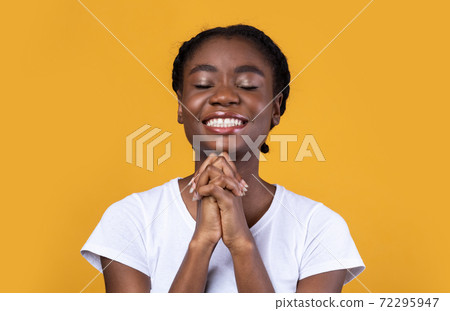 Black Woman Praying Holding Hands In Prayer Gesture, Yellow Background Black Woman Praying Holding Hands In Prayer Gesture, Yellow Background 72295947