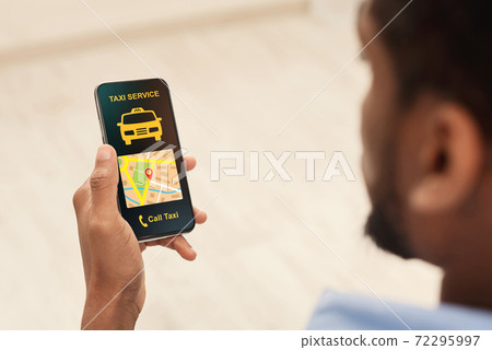 Black man holding cellphone with taxi app interface 72295997