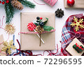 Present in brown craft paper, boxes, candy, plaid and Christmas decoration on table. New Year 72296595