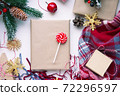 Present in brown craft paper, boxes, candy, plaid and Christmas decoration on table. Copy space. Eco friendly New Year 72296597