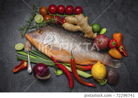 Raw Red snapper fish with spices and herbs ingredients for cooking on dark background., top view 72296741
