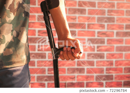 young man with broken leg on crutches. young man with broken leg on crutches. 72296784