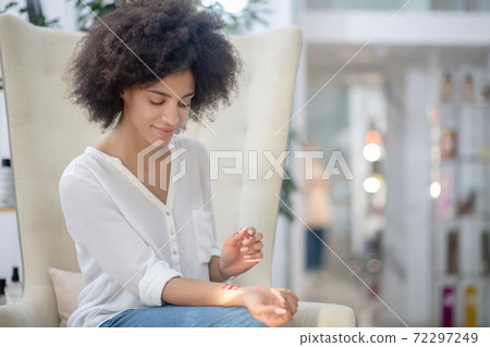 Thoughtful woman leisurely choosing lip pencil 72297249